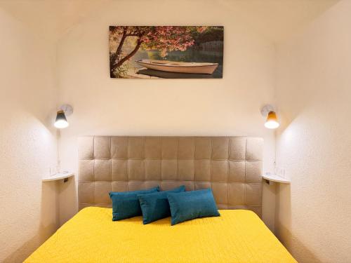 a bedroom with a yellow bed with two blue pillows at Perla Del Borgo in Gallipoli