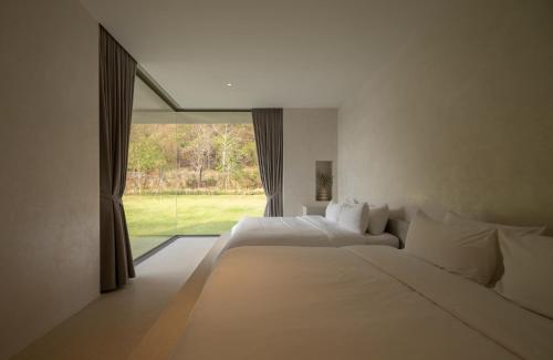 a bedroom with two beds and a large window at Number Three Pool Villa Khaoyai in Ban Tha Maprang