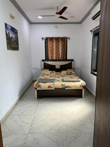 a bedroom with a bed and a ceiling fan at Beach front in Murud