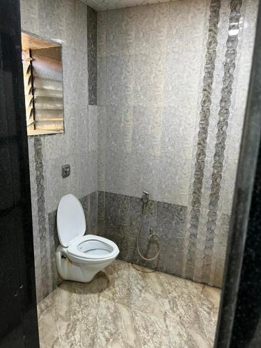 a bathroom with a white toilet in a room at Beach front in Murud