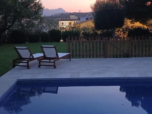 two chairs are sitting next to a swimming pool at Chichen Itza in Moraira