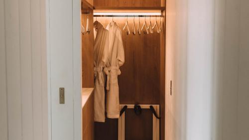 a closet with hangers and white clothes in it at Hôtel Hemen in Saint-Palais-sur-Mer