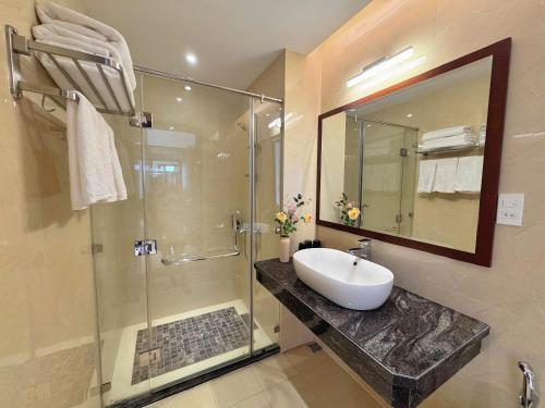 a bathroom with a sink and a glass shower at Ruby hotel Tuần Châu in Ha Long
