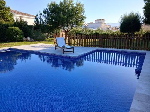 a chair sitting next to a blue swimming pool at Chichen Itza in Moraira