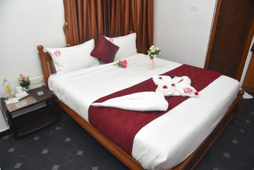 a hotel room with a bed with towels on it at RD Hotel-Near Anna Statue in Perundurai