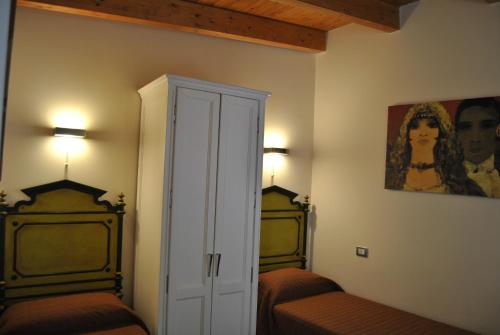 a bedroom with two beds and a painting on the wall at Bed & Breakfast Palazzo Ducale in Andria