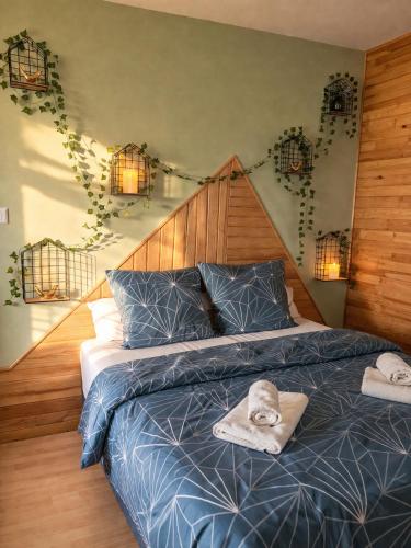 a bed with a blue comforter and towels on it at Haut Doubs Belvédère in Les Hôpitaux-Neufs