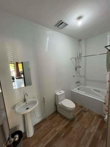 a bathroom with a sink and a toilet and a bath tub at Hollywood Suites Gensan in General Santos