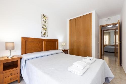 a bedroom with a bed with two towels on it at PINEDA NOU Apartments in La Pineda
