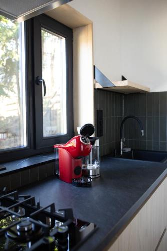a kitchen counter with a red appliance on a counter top at Moho in Yablunytsya