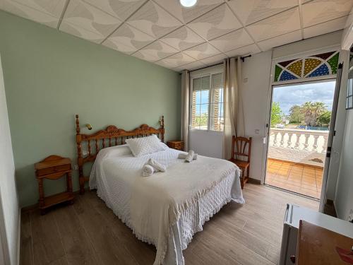 a bedroom with a bed and a large window at Hostal Quinto Pino in Chipiona