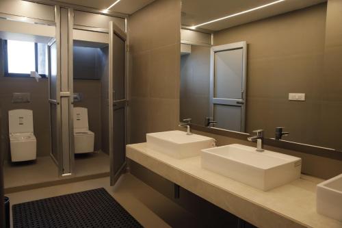a bathroom with two sinks and two toilets at Hotel Subansiri in Dibrugarh