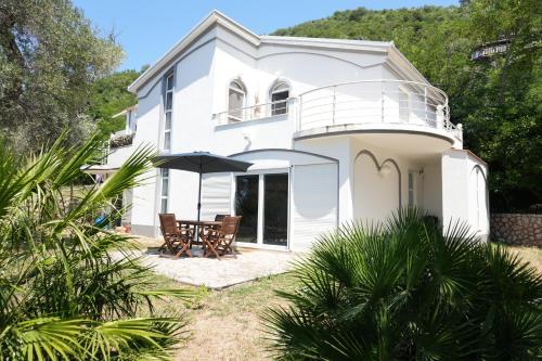 a white house with a balcony and a patio at Vila Brca in Brca