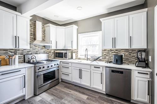 a kitchen with white cabinets and stainless steel appliances at Orange Queen LLC in East Orange