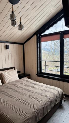 a bedroom with a bed in a room with a window at Mountain soul hub будиночок на схилі in Krasnik
