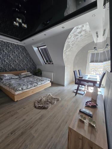 a bedroom with a bed and a table with chairs at Eleganckie Lokum in Malbork
