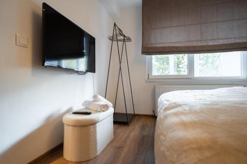 a bedroom with a bed and a flat screen tv at Ovideli Apartment in Ocna-Mureşului