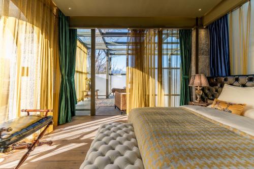 a bedroom with a bed and a large window at Wumo Qinglu Snow Mountain Museum Hotel in Baisha