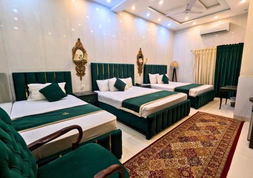 a hotel room with two beds and a couch at Golden One Hotel in Lahore
