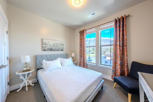 a bedroom with a bed and a window and a chair at Historic Main Street Hotel in Pleasant Grove