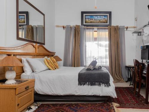 a bedroom with a bed and a mirror and a window at Haweweg 5 in Struisbaai