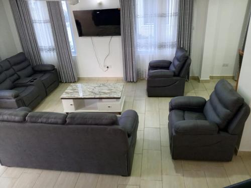 a living room with two couches and a tv at Greenwood Apartments in Mtwapa