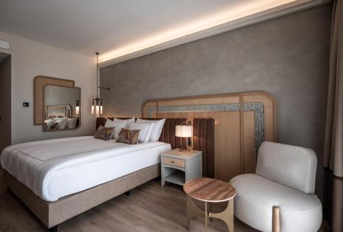 a bedroom with a large bed and a chair at Adalya Bliss in Side
