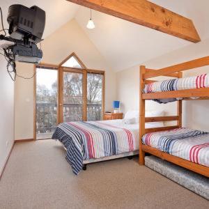 a bedroom with two beds and a television in it at Square Bear in Dinner Plain
