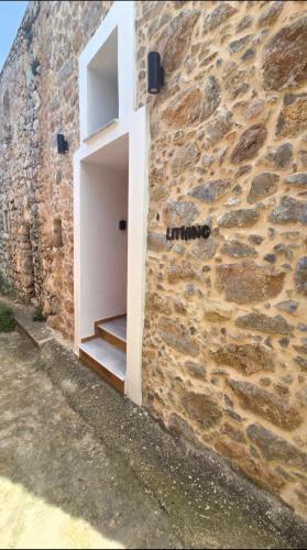 a door in a stone wall with a stairway at Lithino in Líthion