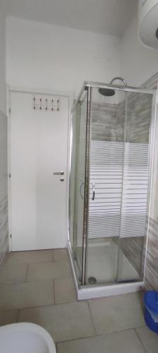 a glass shower in a bathroom with a toilet at Alloggio Tommy in Biella
