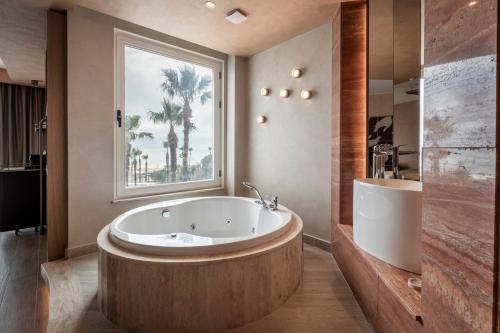 a large bathroom with a large tub and a window at Adalya Bliss in Side
