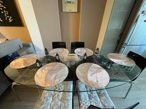 a glass table with four chairs around it at Sousse appartement zone touristique in Sousse