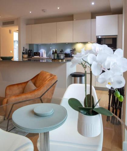 a living room with a table and a vase with white flowers at Westminster 1 bed apt with terrace and Air-Con in London
