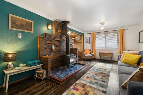 a living room with a brick fireplace and a couch at Lady Marmalade in Blackheath