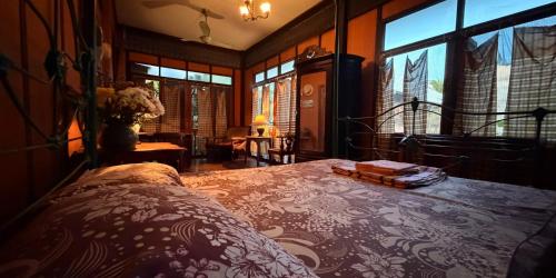 a bedroom with a bed in a room with windows at Villa Guesthouse Bangkok in Bangkok