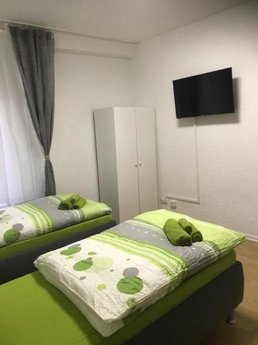a bedroom with two beds and a flat screen tv at Easy Stay Monteurswohnung in Geislingen an der Steige