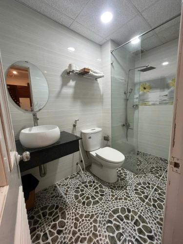 a bathroom with a toilet and a sink and a shower at Queen-Hotel in Quy Nhon
