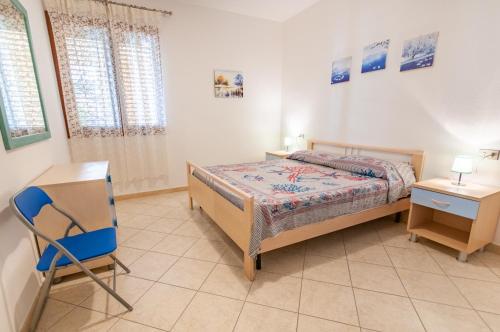 a bedroom with a bed and a desk and a chair at Appartamento Pina Caletta sul mare con parcheggio privato in La Caletta