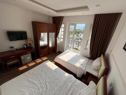 a hotel room with two beds and a window at Queen-Hotel in Quy Nhon