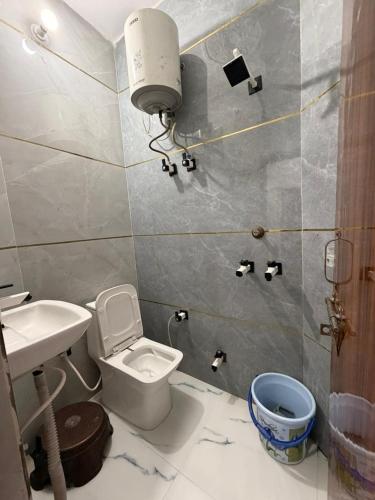 a bathroom with a white toilet and a sink at Nisha sadan in Vrindāvan