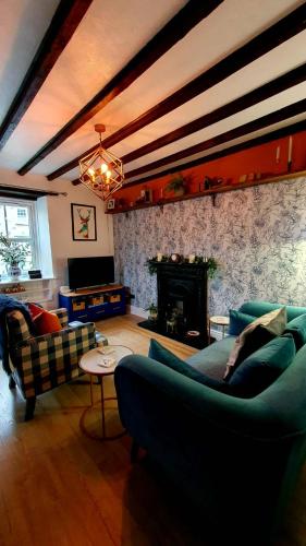 a living room with blue couches and a fireplace at Beatrice Cottage in Richmond