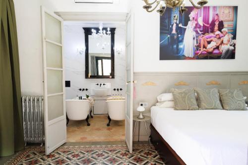 a bedroom with two tubs and a bathroom with a sink at Dog Admiral - Urban Guest House in Palma de Mallorca