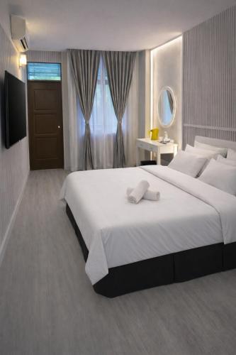 a bedroom with a large white bed and a window at Hotel Darulaman Jitra in Jitra