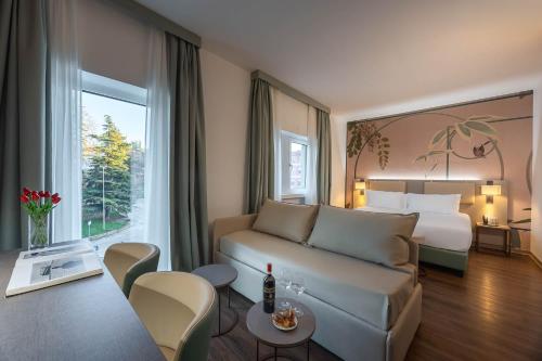 a hotel room with a couch and a bed at Hotel Castello in LʼAquila