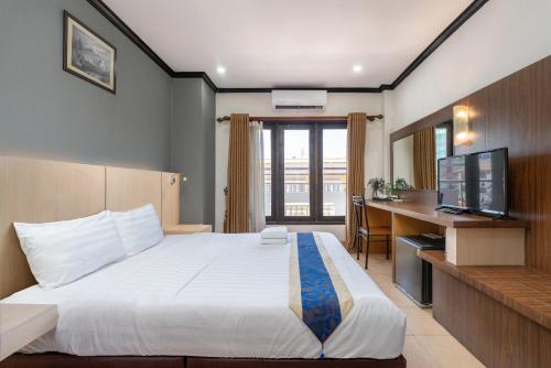 a hotel room with a large bed and a desk at Lucky city hotel in Vientiane