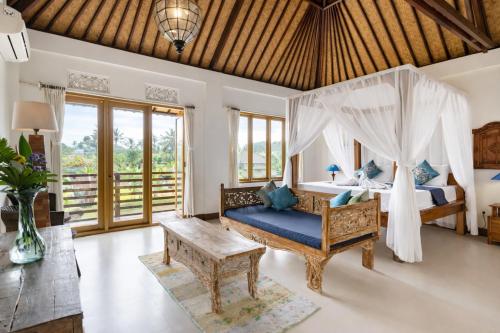 a bedroom with a bed with a canopy at Villa Kami Ubud in Ubud