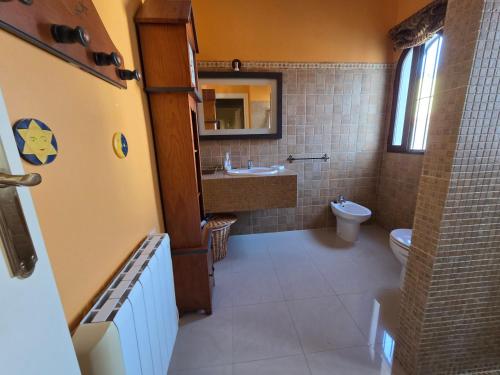 a bathroom with a toilet and a sink and a mirror at CasaManuelaMonesterio in Monesterio