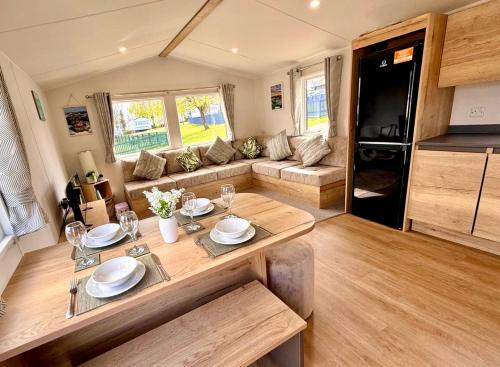 a caravan living room with a table and a couch at Shamrocks Cove Caravan - Award-Winning Coastal Retreat in Crantock