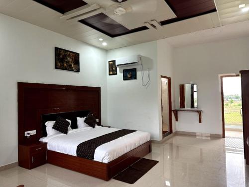 a bedroom with a large bed in a room at Kuyal Corbett Resort in Rāmnagar