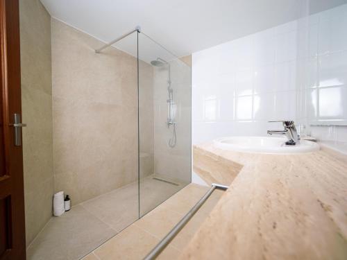 a bathroom with a sink and a glass shower at Prope Mare Apartamentos in Cala Millor